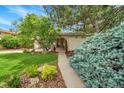 View of the front entrance with brick accents and well-manicured landscaping at 11496 E Wesley Ave, Aurora, CO 80014