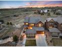 Stunning two-story home with a three-car garage and beautifully landscaped yard, set against a picturesque sunset backdrop at 10580 Greycliffe Dr, Highlands Ranch, CO 80126