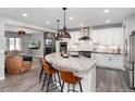 Spacious open-concept kitchen flowing into the living area, showcasing a large island, stainless appliances, and a cozy fireplace at 10580 Greycliffe Dr, Highlands Ranch, CO 80126