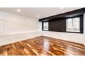 Finished basement with light wood flooring, white wainscoting and a dark painted ceiling beam at 21743 Farmingdale Ct, Parker, CO 80138