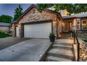 Home exterior with a three-car garage and inviting entrance featuring stone details and manicured landscaping at 8657 Aberdeen Cir, Highlands Ranch, CO 80130
