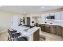 Open concept kitchen with stainless appliances, quartz countertops, island cooktop, and a breakfast bar at 1880 E 81St Pl, Denver, CO 80229