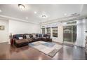 Spacious living room boasting hardwood floors, a comfortable leather sectional, and lots of natural light at 11511 E 118Th Ave, Commerce City, CO 80640