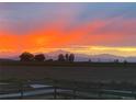 Incredible sunset view over rolling hills with a dramatic orange sky, capturing the beauty of nature at 17786 Olive St, Broomfield, CO 80023