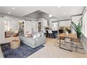 Bright, open-concept living room with modern furnishings, a large couch, and a spacious kitchen area at 2517 W 44Th Ave, Denver, CO 80211