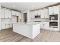 Modern kitchen features white cabinets, an island, stainless steel appliances, and beautiful countertops at 25076 E 41St Ave, Aurora, CO 80019