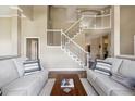Spacious foyer featuring a grand staircase, neutral paint, and wood floors at 9524 E Caley Cir, Englewood, CO 80111
