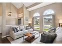 Light-filled living room with vaulted ceilings, oversized windows, and comfortable furnishings at 9524 E Caley Cir, Englewood, CO 80111