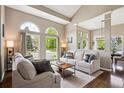 Bright living room with large arched windows, vaulted ceilings, neutral paint, and comfortable seating at 9524 E Caley Cir, Englewood, CO 80111