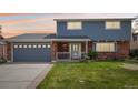 Traditional home featuring a brick and siding exterior, two-car garage, and manicured front lawn at 8732 W Arbor Ave, Littleton, CO 80123