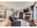 Cozy living room featuring a modern fireplace, mounted TV, and staircase access at 9672 W Chatfield Ave # C, Littleton, CO 80128
