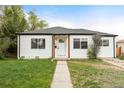 Charming single-story home with a well-maintained lawn, light-colored siding and a cozy front porch at 1213 Jamaica St, Aurora, CO 80010