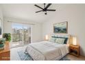 Comfortable bedroom with a walk-out balcony, bright light, and a ceiling fan at 1495 Blue Sky Way # 9-308, Erie, CO 80516