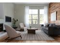 Inviting living room with hardwood floors, a modern wood accent wall, and large window with natural light at 8774 Martin Luther King Blvd, Denver, CO 80238