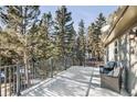 Expansive deck overlooking lush trees with comfortable seating, perfect for enjoying serene outdoor living at 30633 Kings Valley Dr, Conifer, CO 80433