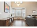 Bright living room with high ceilings, hardwood floors, and a large bay window at 10741 Idalia Way, Commerce City, CO 80022