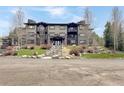 Three story condo building with green and brown colors, stairs leading up to the main doors and balcony at 290 Broken Lance Dr # B104, Breckenridge, CO 80424