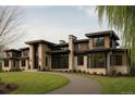 Striking modern home with stone and wood accents, large windows, and a curved driveway at 90 Meade Ln, Englewood, CO 80113