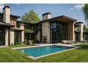 Gorgeous backyard featuring a modern pool, fireplace, and outdoor seating area for entertaining at 90 Meade Ln, Englewood, CO 80113