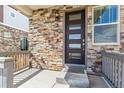 Close-up of a stylish front door with modern design, stone facade, and covered porch at 21761 E 7Th Ave, Aurora, CO 80018