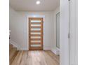 Bright entryway with a modern front door and hardwood floors, leading to the staircase at 3711 Pecos St, Denver, CO 80211