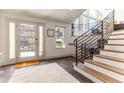 Bright foyer with modern staircase, large windows, and stylish tile flooring at 10395 W 74Th Pl, Arvada, CO 80005