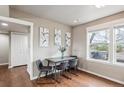 A dining room with hardwood floors, a table, four chairs, and a window at 1095 W 69Th Ave, Denver, CO 80221