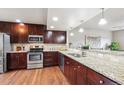 A kitchen featuring stainless appliances, granite countertops and dark wood cabinets at 1095 W 69Th Ave, Denver, CO 80221