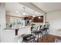 A kitchen area with a breakfast bar and granite countertops, featuring three barstools at 1095 W 69Th Ave, Denver, CO 80221