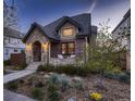Charming brick and stone home with manicured front yard and inviting covered porch at 519 S Gaylord St, Denver, CO 80209