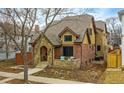 Brick and stone home with covered porch, two chairs and a lush garden at 519 S Gaylord St, Denver, CO 80209