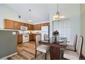 Bright eat-in kitchen with wood cabinets, modern appliances, a dining table, and hardwood flooring, perfect for Gathering meals at 3250 E 103Rd Pl # 805, Thornton, CO 80229