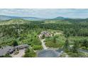 Gorgeous home surrounded by lush trees with a long driveway leading to the house at 8403 Homestake Ct, Larkspur, CO 80118