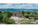 Stunning exterior of home with an attached garage and a small outbuilding at 8403 Homestake Ct, Larkspur, CO 80118