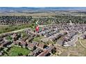 Expansive aerial view of a residential area with homes, roads and grassy areas with surrounding mountain scenery at 4090 Forever Cir, Castle Rock, CO 80109