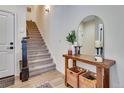 An inviting entryway featuring a wooden console table, decorative mirror, and staircase, providing a warm welcome at 12193 W 51St Ave, Wheat Ridge, CO 80033