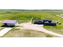 Aerial view of a modern home with a large garage and beautiful grounds at 26100 County Road 5, Elizabeth, CO 80107
