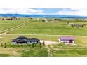 Aerial view of the property with modern home, garage, and mountain views at 26100 County Road 5, Elizabeth, CO 80107