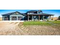 Modern farmhouse exterior with a three-car garage and covered porch at 26100 County Road 5, Elizabeth, CO 80107