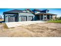 Three-car garage with concrete driveway and landscaping at 26100 County Road 5, Elizabeth, CO 80107