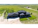 Aerial view of home showing three car garage, covered porch and landscaping at 26100 County Road 5, Elizabeth, CO 80107