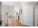 Bright foyer features wood floors, high ceilings, and a view of the living room and kitchen at 2629 Wisteria Dr, Erie, CO 80516