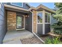 Charming front entrance with gray siding, stone accents, a bay window, and a welcoming front door at 2629 Wisteria Dr, Erie, CO 80516