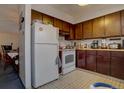 Small kitchen with dark wood cabinets and white appliances at 6495 E Happy Canyon Rd # 88, Denver, CO 80237