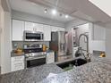 Modern kitchen featuring stainless steel appliances, granite countertops, and in-unit laundry at 7379 S Gore Range Rd # 304, Littleton, CO 80127