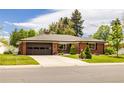 Charming brick ranch-style home featuring a well-manicured lawn, a two-car garage, and mature trees at 428 W Valleyview Ave, Littleton, CO 80120