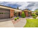 Quaint brick home with a covered entryway, tidy landscaping, and a two-car garage at 428 W Valleyview Ave, Littleton, CO 80120