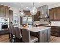 Gourmet kitchen with stainless steel appliances, marble countertops, and a stylish island with seating at 2730 Fox View Trl, Franktown, CO 80116