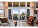Bright living room features a stone fireplace, comfortable seating, and sliding glass doors leading to the outside at 2730 Fox View Trl, Franktown, CO 80116
