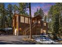 Charming two-story home with an inviting entrance and scenic wooded surroundings at 6752 S Columbine Rd, Evergreen, CO 80439